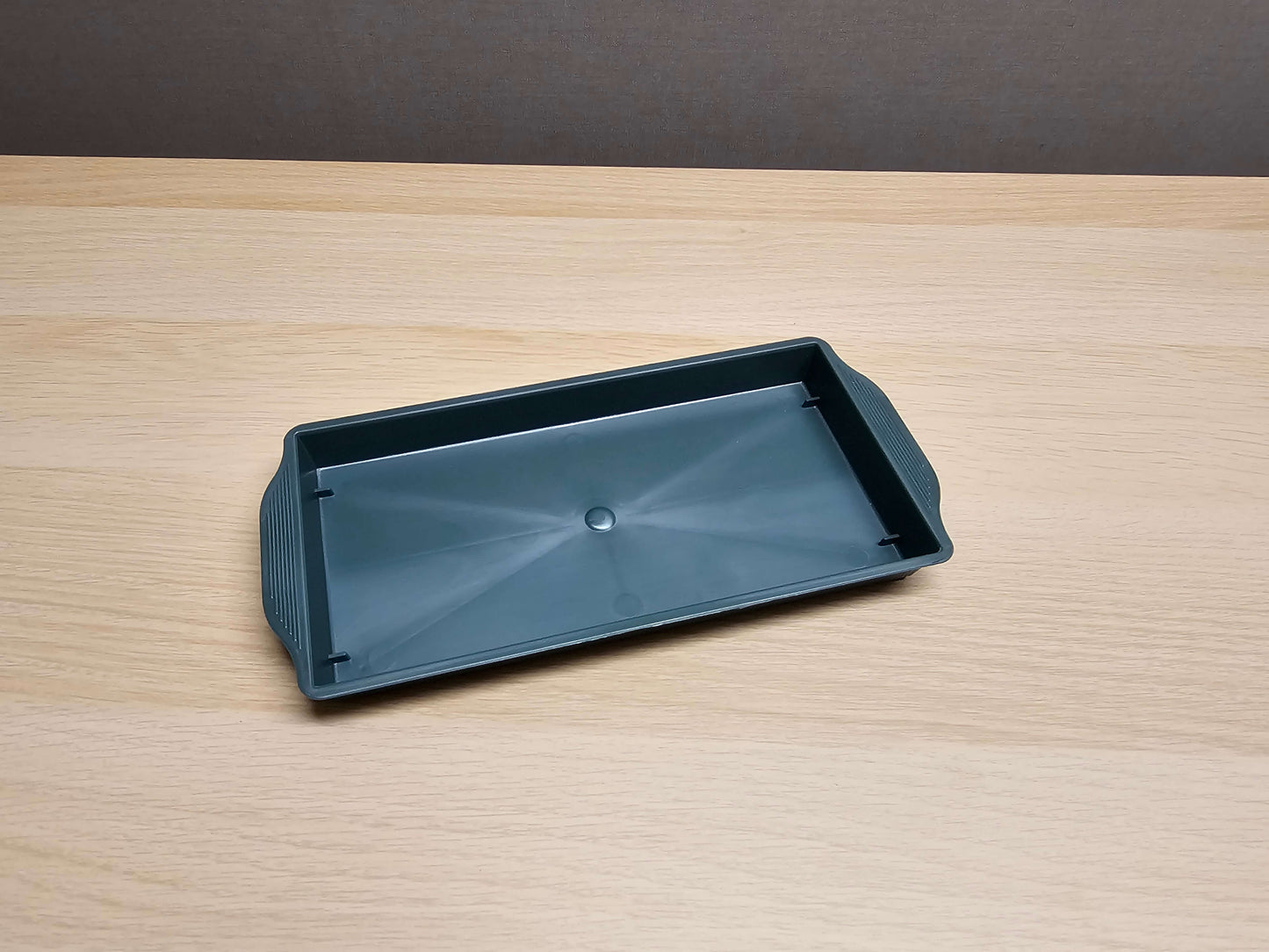 An overview of a Oasis® Green Single Brick Floral Tray (25 x 13 x 3cm) sitting a wooden table