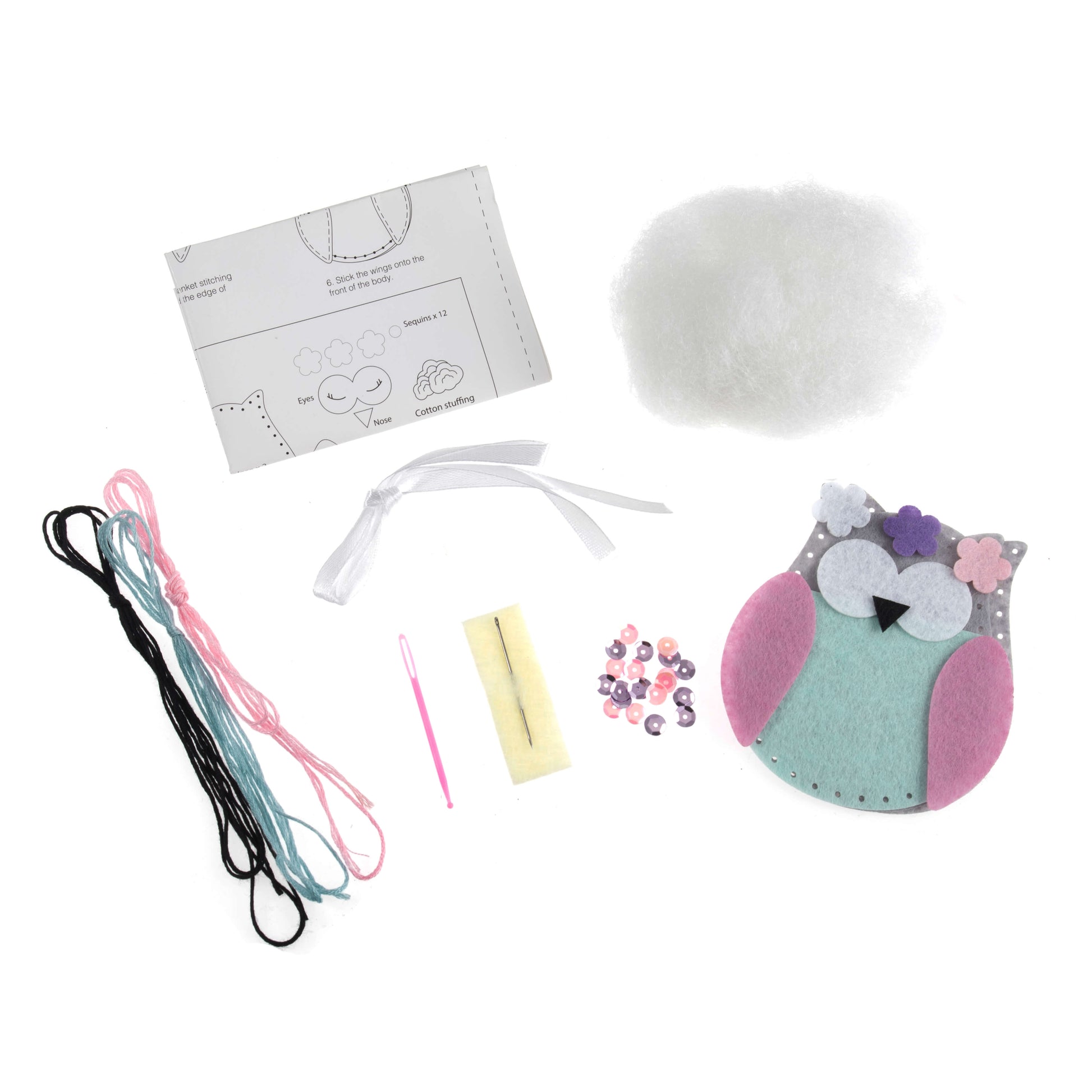 A photo of a kit to make a felt owl, with the owl partially assembled and instructions visible.