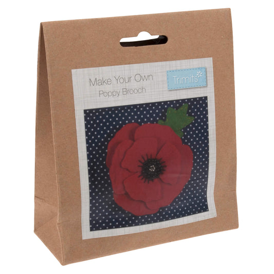  The image shows a poppy brooch in a box on a polka dot background.