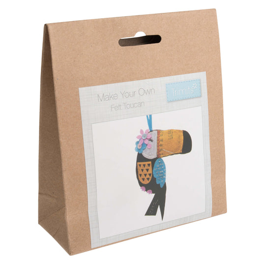 The image shows a felt toucan in a box with a flower on its head.