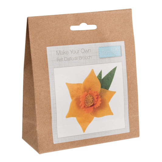 A photo of a felt daffodil brooch kit in a brown paper bag.
